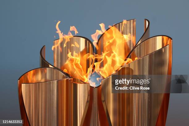 The Olympic cauldron is lit during the 'Flame of Recovery' special exhibition at Aquamarine Park a day after the postponement of the Tokyo 2020...