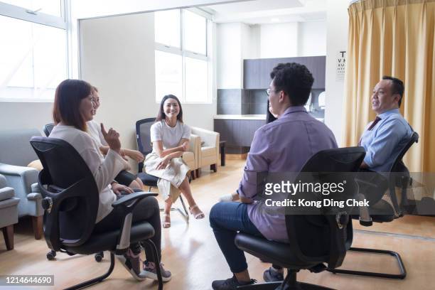 a group of doctors having discussion with smiling face in doctor's office at hospital - busy hospital lobby stock pictures, royalty-free photos & images