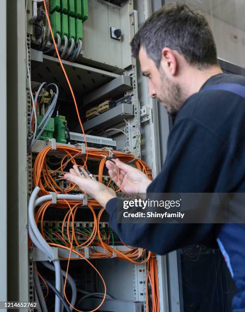 it-techniker steckte glasfaserkabel in schalter - kompetenz bündeln stock-fotos und bilder