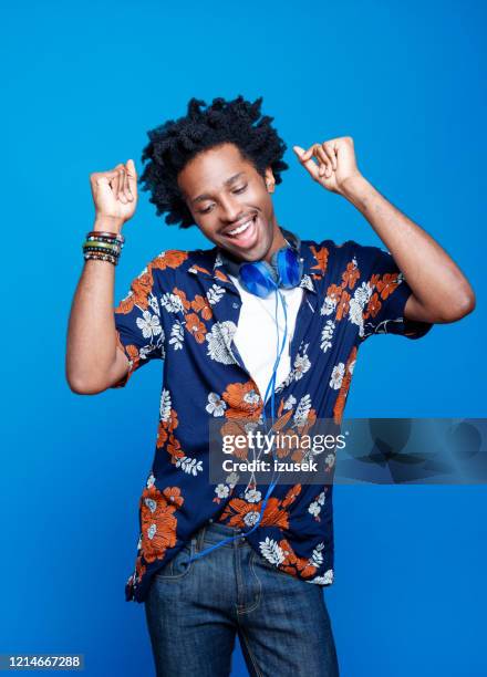 studio portrait of dancing young man in hawaiian shirt - music inspired fashion stock pictures, royalty-free photos & images