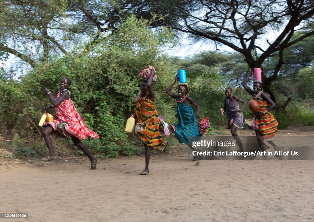 Toposa tribe women running with stuff on their heads, Namorunyang State, Kapoeta, South Sudan...