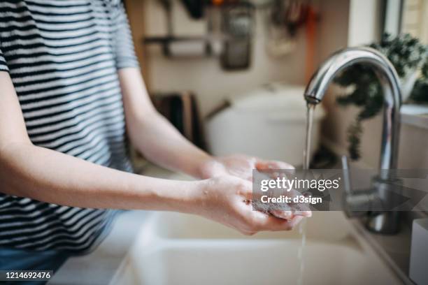 cropped shot of a woman maintaining hands hygiene and washing hands with soap in the sink - washing hands photos et images de collection