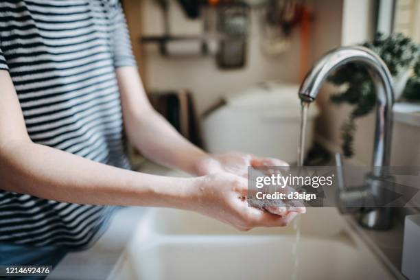 cropped shot of a woman maintaining hands hygiene and washing hands with soap in the sink - washing hands stock pictures, royalty-free photos & images
