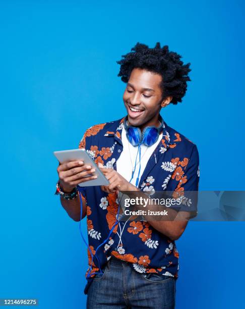 glimlachende mens in hawaiian overhemd dat digitale tablet houdt - man ipad holiday stockfoto's en -beelden