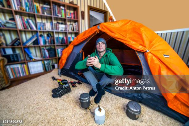 a young man in a tent inside the house. - covid 19 travel stock pictures, royalty-free photos & images