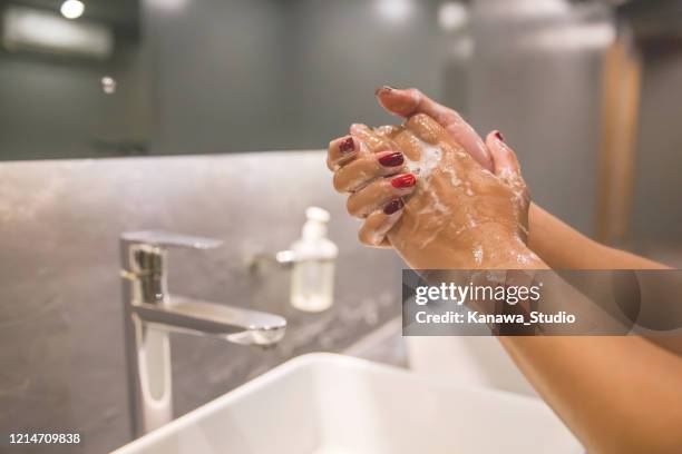 geschäftsfrau händewaschen mit seife, um coronavirus zu verhindern - office bathroom stock-fotos und bilder