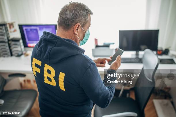 un agente senior dell'fbi con maschera protettiva in ufficio - fbi agents foto e immagini stock