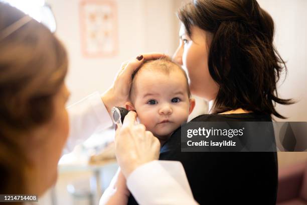 a baby and her doctor - ear exam stock pictures, royalty-free photos & images