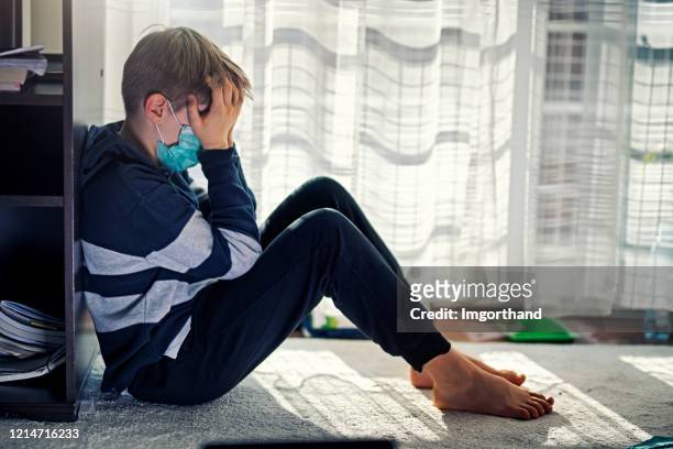 ragazzo depresso durante la quarantena epidemica - pandemic illness foto e immagini stock