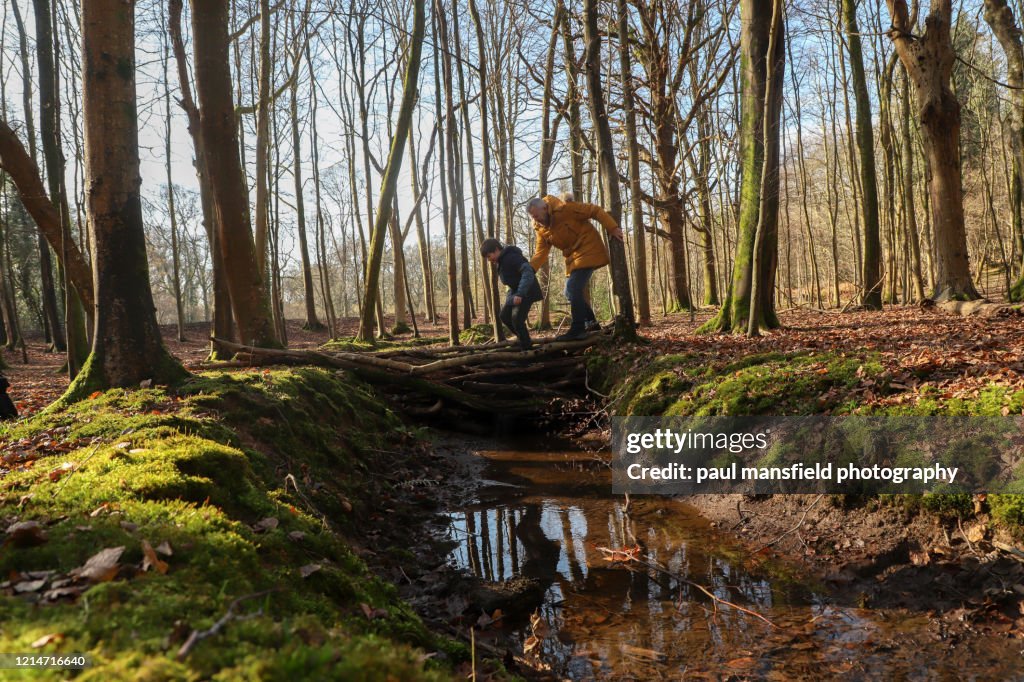 Father and son crossing a stream