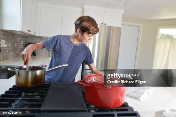 young teenager cooking - boy cooking stock pictures, royalty-free photos & images
