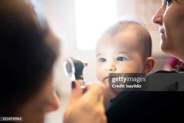 ein baby und ihr arzt - human eye stock-fotos und bilder