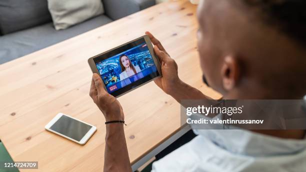 empresario en aislamiento viendo a presentador de noticias presentando las noticias de última hora durante un estado de emergencia - news event fotografías e imágenes de stock