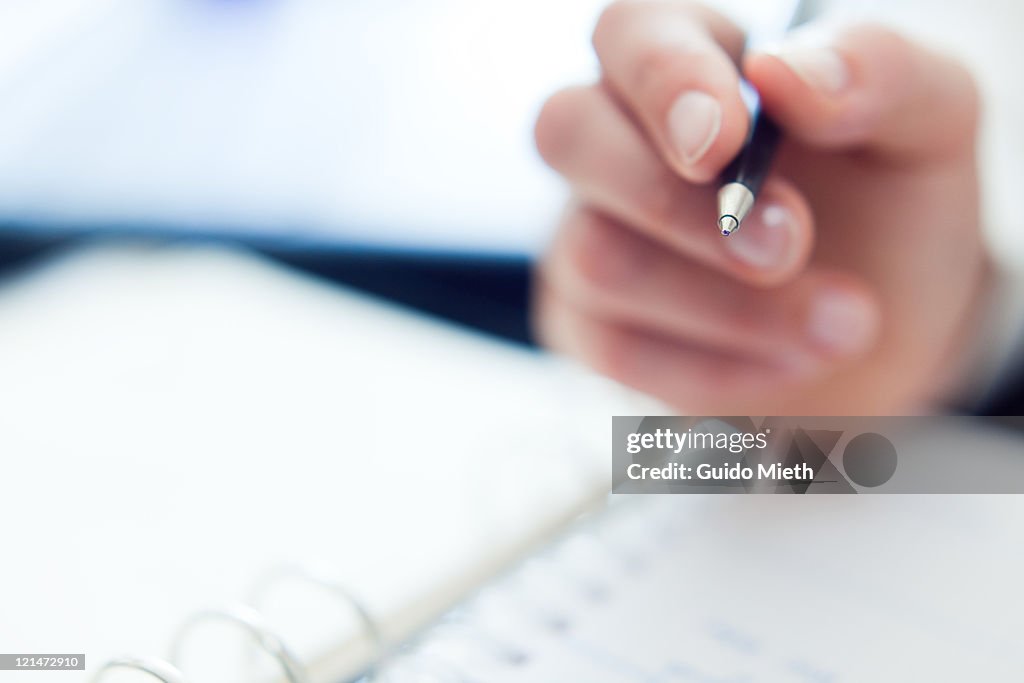 Woman hand, ball pen and organizer