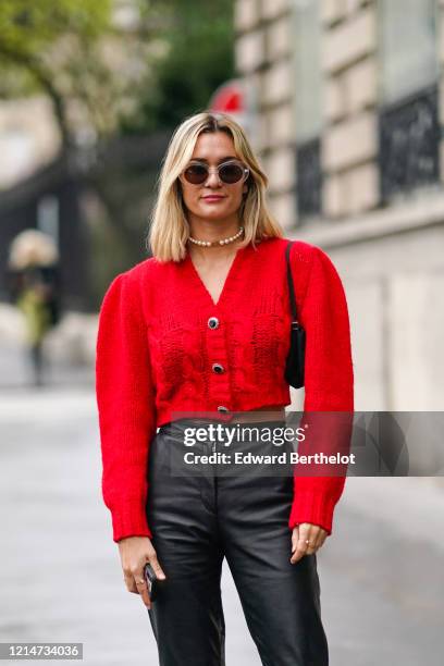 Anne-Laure Mais wears sunglasses, a necklace, a red wool jacket, black leather pants, outside Alessandra Rich, during Paris Fashion Week - Womenswear...