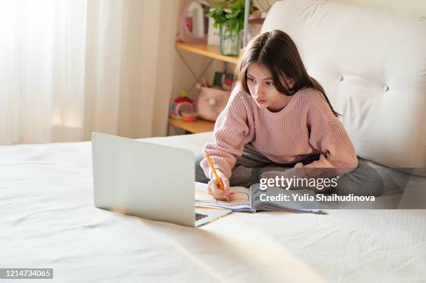 home schooling during the covid-19 quarantine. coronavirus isolation. studying from home. - young girls homework stock-fotos und bilder