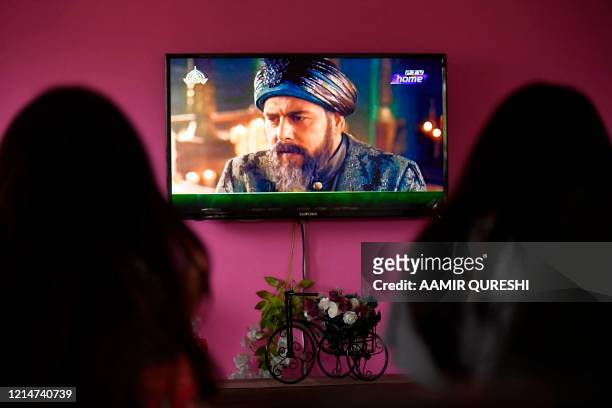 In this picture taken on May 9 a family watches a Turkish drama series "Dirilis: Ertugrul" telecasted on Pakistan's state-run channel PTV Home during...