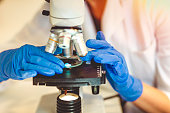 Women scientist research and looking microscope in a laboratory