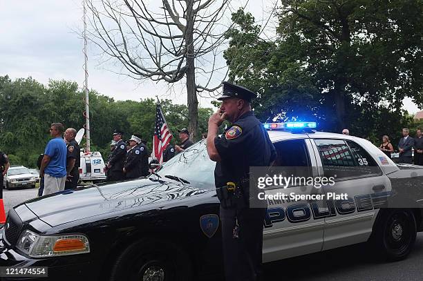 Residents and police watch as the casket for U.S. Navy Petty Officer Brian Bill heads into the Church of St. Cecilia on August 19, 2011 in Stamford,...