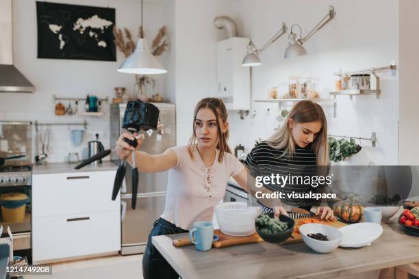 zwei jugendliche influencer machen eine web-show über das kochen veganer speisen - cooking show stock-fotos und bilder