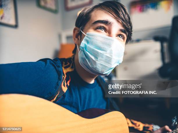covid-19, tonåring spelar gitarr i sitt rum - masked musicians bildbanksfoton och bilder