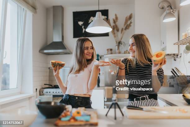 two teenage girlfriends filming a music video in the kitchen with smart phone - cute 15 year old girls stock pictures, royalty-free photos & images