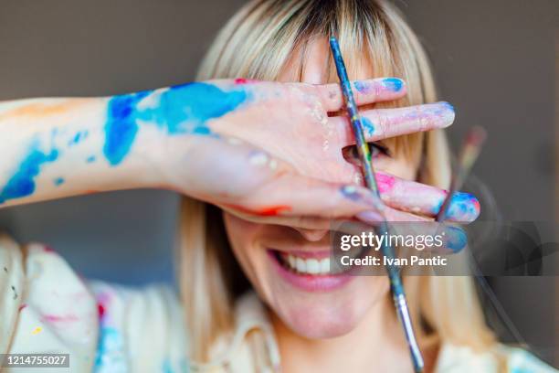 porträt einer jungen blonden künstlerin - a woman with paint stock-fotos und bilder