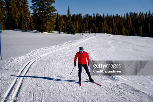 ein mann langlauf an einem schönen sonnigen tag - cross country skis stock-fotos und bilder