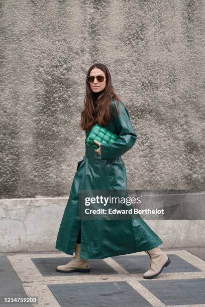 Erika Boldrin wears sunglasses, a green shiny leather long trench coat, a green quilted Bottega Veneta bag, beige boots, outside Loewe, during Paris...