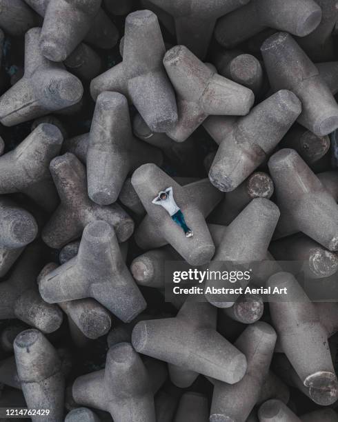 aerial image above one person lying on a tetrapod structure, italy - full size stock-fotos und bilder