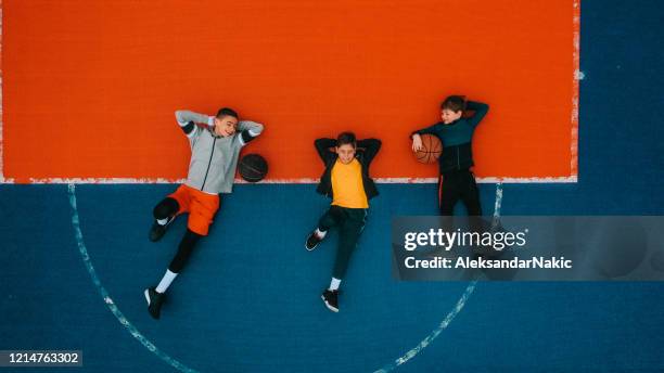 descansando en una cancha de básquetbol - drone kid fotografías e imágenes de stock