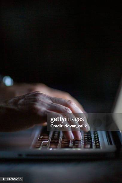 close up of hands typing on laptop. night work concept. - laptop dark stock pictures, royalty-free photos & images