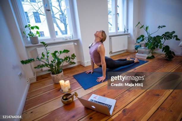 Marlene of Yoga on the Move Berlin warms up prior online stream session in her home on March 25, 2020 in Berlin, Germany. Small businesses are trying...