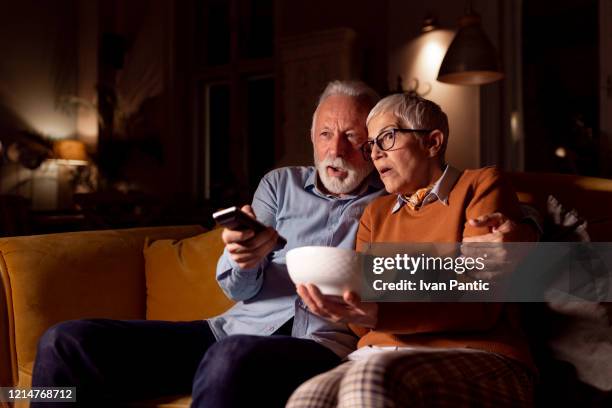 elderly couple spending time together at home - bad news on tv stock pictures, royalty-free photos & images