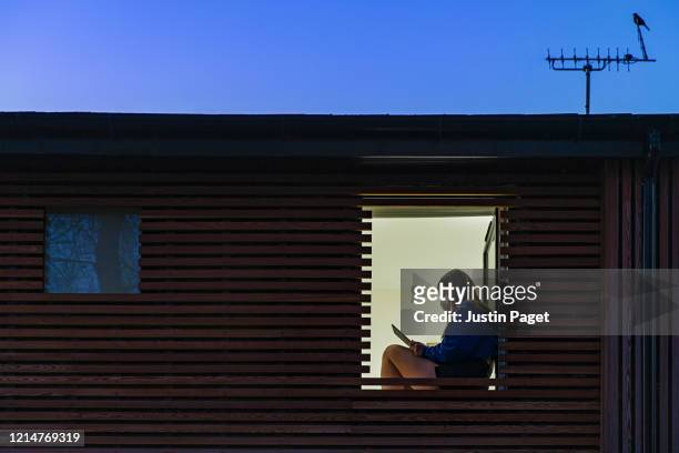 teenage girl wearing mask sitting in her window - quarantine stock pictures, royalty-free photos & images