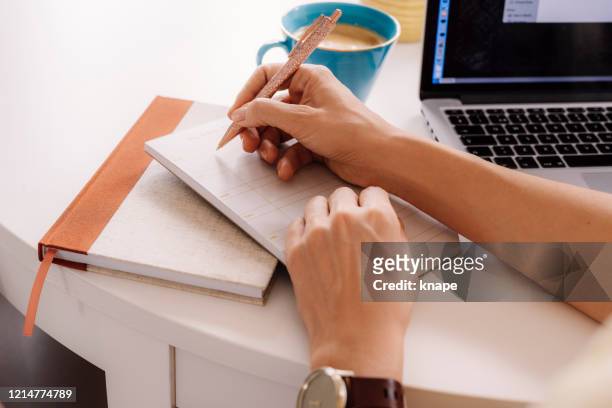 woman working and planning her week hand notes and pen - week stock pictures, royalty-free photos & images