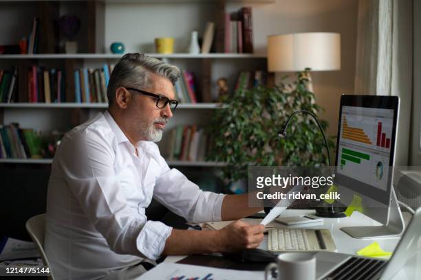 man using desktop pc at desk in home office - market research stock pictures, royalty-free photos & images
