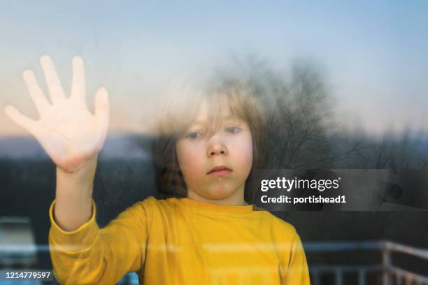 sad child in isolation at home - looking through window covid stock pictures, royalty-free photos & images