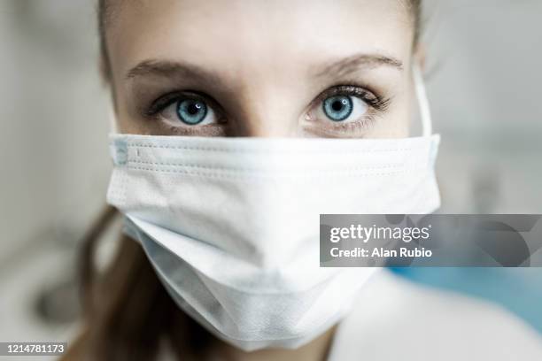 blue-eyed nurse at her workplace wearing a protective mask. - masque de chirurgien photos et images de collection