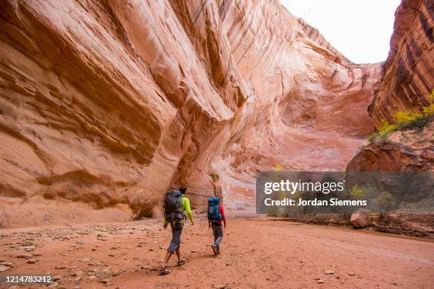 hiking a slot canyon in the utah desert - slot canyon fotografías e imágenes de stock