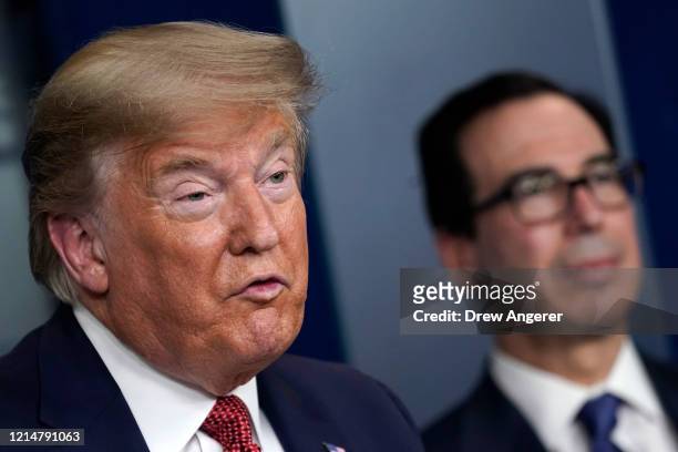 President Donald Trump, joined by Secretary of the Treasury Steven Mnuchin, speaks during a briefing on the coronavirus pandemic, in the press...