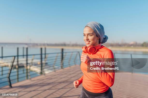 attractive middle eastern woman jogging - women with hijab stock pictures, royalty-free photos & images