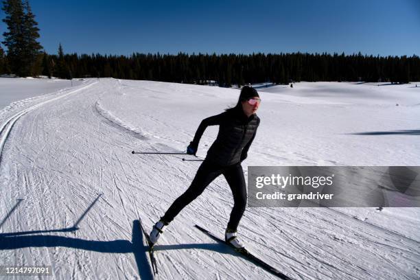 eine frau langlauf an einem schönen sonnigen tag - cross country skis stock-fotos und bilder