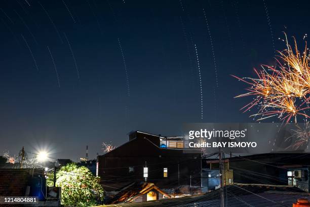 This multiple exposure picture shows fireworks among stars exploding in the sky during the Eid al-Fitr celebrations which marks the end of the Muslim...