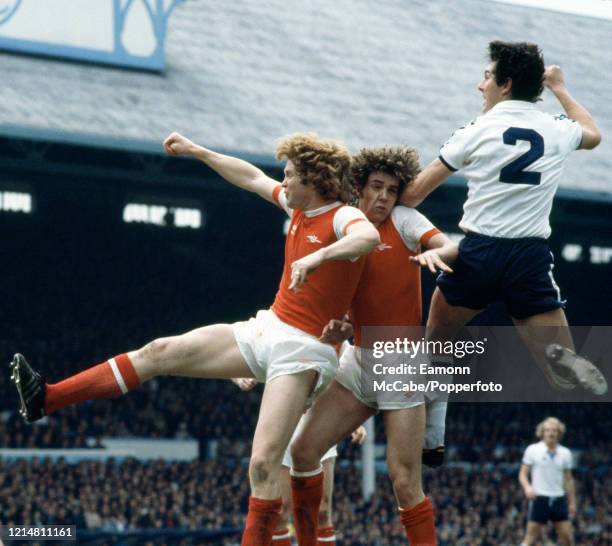 Paul Miller of Tottenham Hotspur rises above Arsenal teammates Paul Vaessen and Willie Young during a Football League Division One match at White...