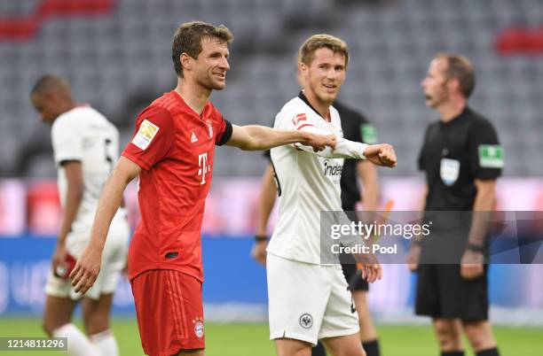 Thomas Muller of FC Bayern Muenchen interacts with Erik Durm of Eintracht Frankfurt after the Bundesliga match between FC Bayern Muenchen and...