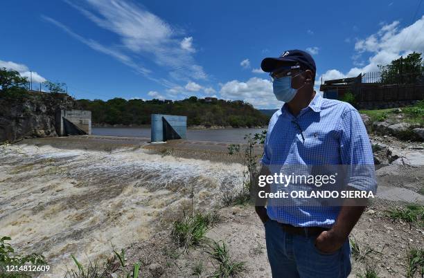 An employee of the government's National Water and Sewage Service observes Los Laureles reservoir on the outskirts of Tegucigalpa on May 23, 2020...