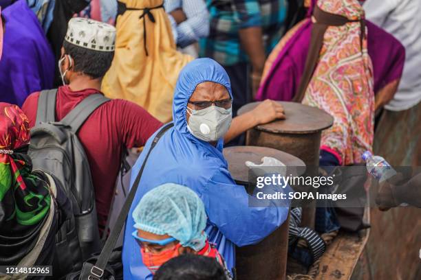 Man is seen wearing a facemask, gloves and protective clothing as a precaution against Covid-19 while on an overcrowded ferry during Eid al-Fitr ....