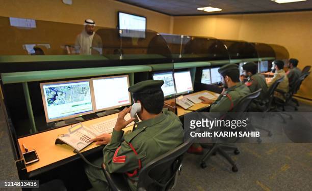 Police officers monitor the streets and receive calls from citizens at the Command and Control Center of Dubai Police in the Gulf emirate, on...