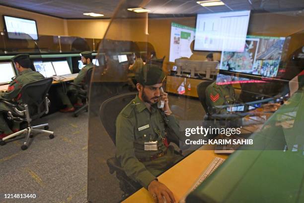 Police officers monitor the streets and receive calls from citizens at the Command and Control Center of Dubai Police in the Gulf emirate, on...